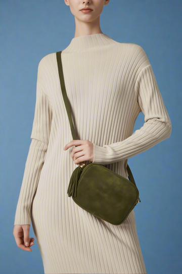 Model wearing the Olive Éloise suede tassel bag crossbody over a knit dress
