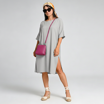 Woman wearing the Fuchsia Beatrice crossbody bag over a grey dress