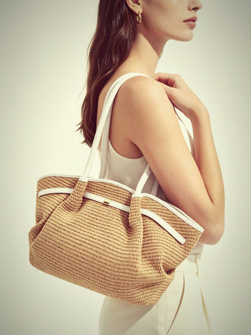 Woman wearing the Oyster Serafina raffia shopper on her shoulder