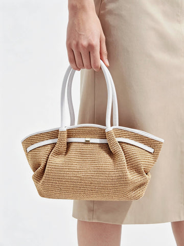Woman holding the Oyster Serafina raffia shopper by its handles