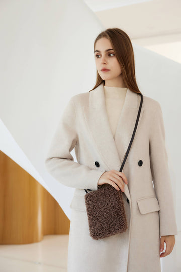 Woman wearing the Mocha Pia phone bag crossbody in a cream coat