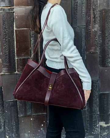 Woman wearing the Burgundy Bianca Large suede tote on her shoulder