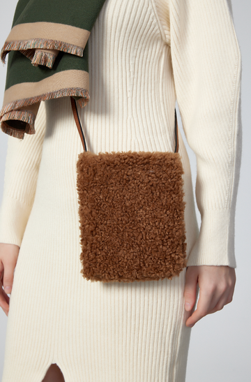 Woman wearing the Mocha Pia phone bag crossbody in a cream knit