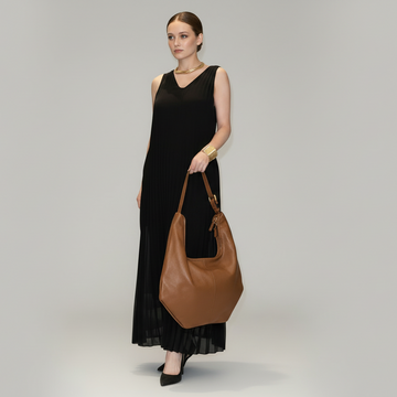 Woman holding the Tan Ludovica hobo bag in a black dress