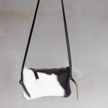 Anouk Cowhide Crossbody by Clemés in Black Pied, three-quarter studio shot on grey background