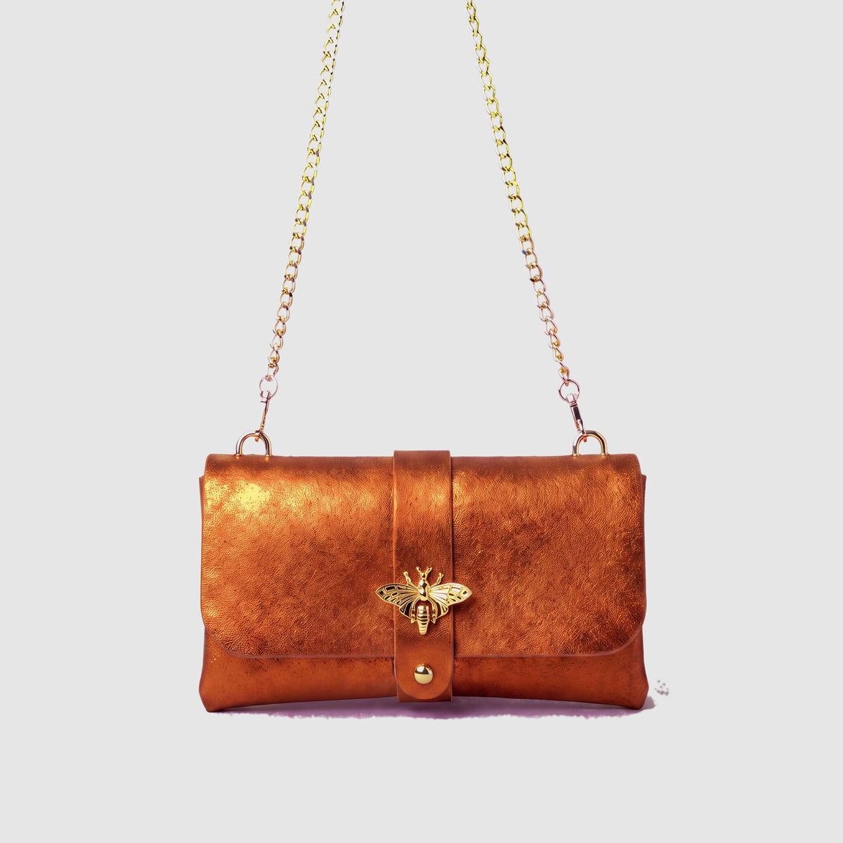 Anima Suede Leather Metallic Clutch Shoulder Bag by Clemés in Orange, studio shot on grey background