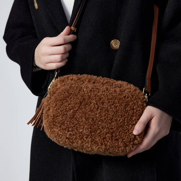 Georgette Shearling & Leather Tassel Camera Bag by Clemés in Taupe, held in hand