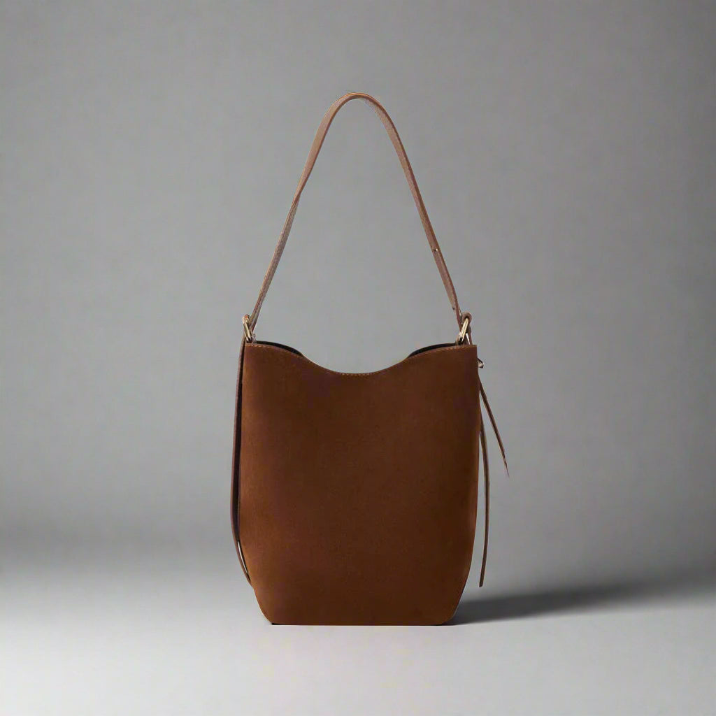 Serena Suede & Leather Bucket Shoulder Bag by Clemés in Chocolate, three-quarter studio shot on grey background
