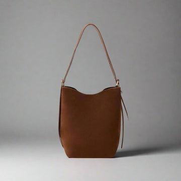 Serena Suede & Leather Bucket Shoulder Bag by Clemés in Chocolate, three-quarter studio shot on grey background