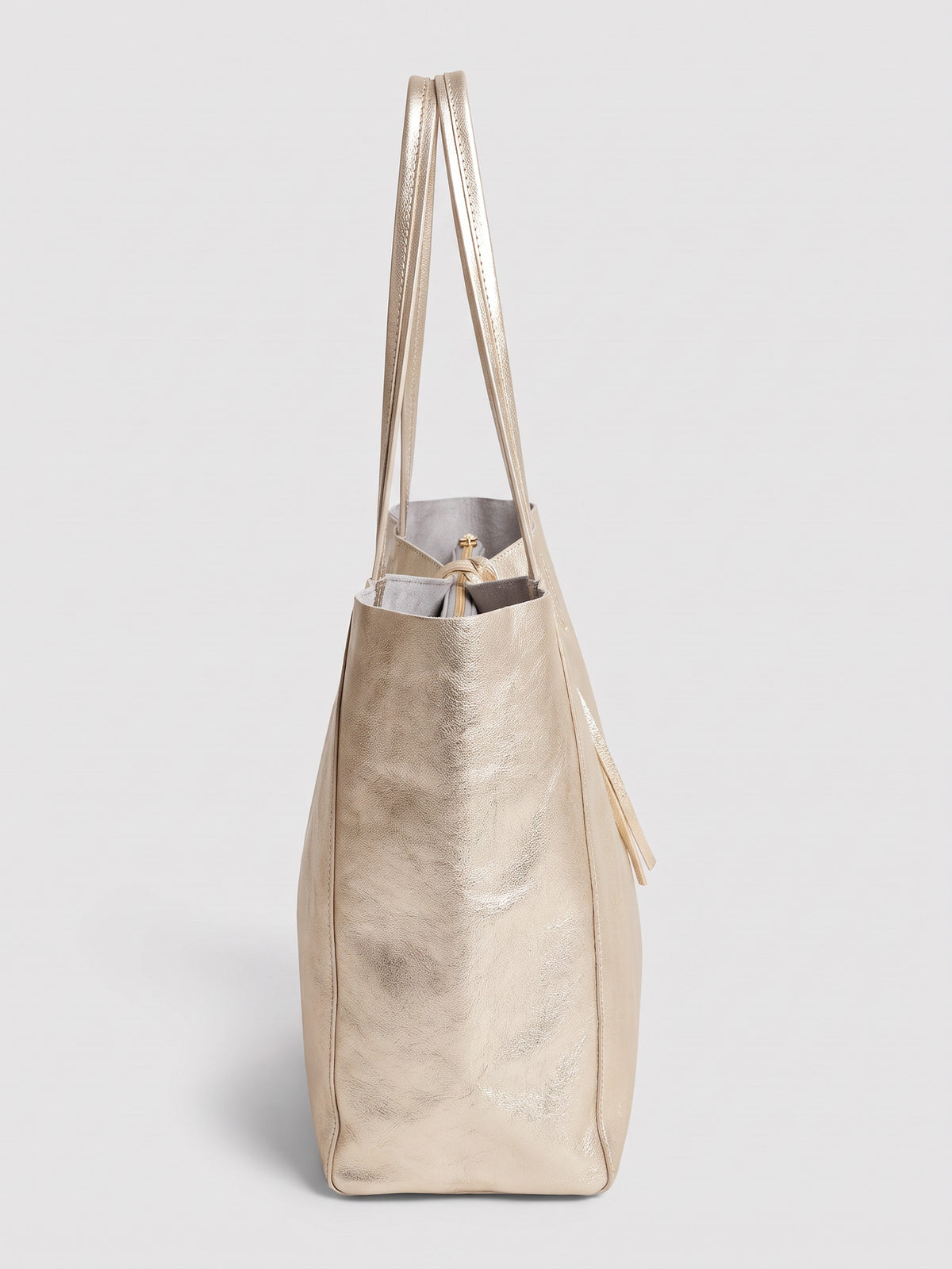 Carlotta oversized leather tote by Clemés in Champagne Gold metallic leather, side profile view