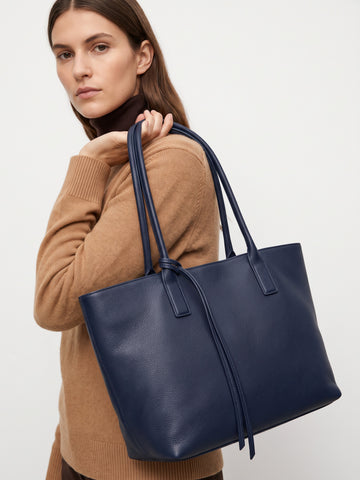 Carlotta oversized leather tote by Clemés in Navy leather, lifestyle shot carried by a model