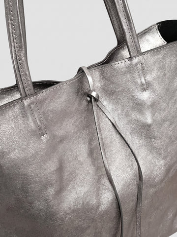 Carlotta oversized leather tote by Clemés in Titanium metallic leather, close-up of the top edge with rolled handles and knotted leather tie