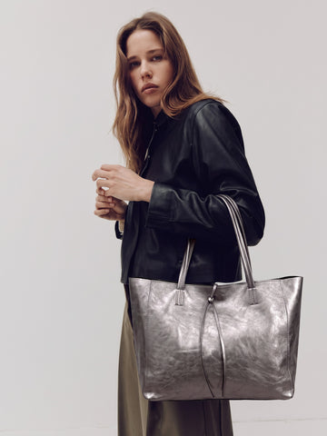 Carlotta oversized leather tote by Clemés in Titanium metallic leather, lifestyle shot carried by a model