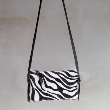 Anouk Cowhide Crossbody by Clemés in Zebra, three-quarter studio shot on grey background
