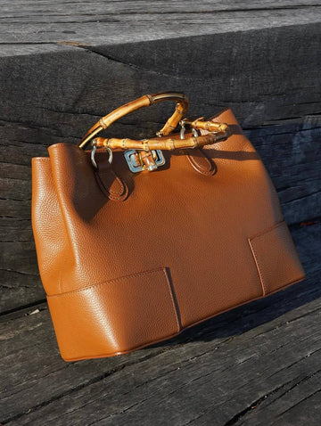 Ginevra Bamboo-Handle Leather Bag by Clemés in Cognac, three-quarter studio shot on grey background