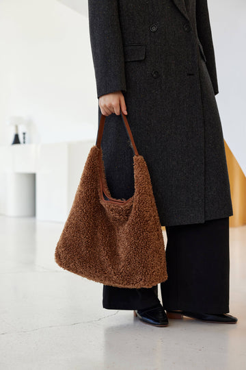 Woman carrying the Mocha Anaïs hobo bag in a dark coat
