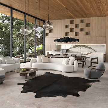 Black cowhide rug in a bright modern living room with wood-slat ceiling