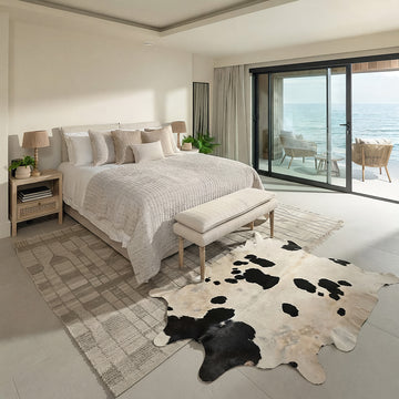 Black and white cowhide rug in a coastal ocean-view bedroom