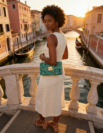 Woman with the Turquoise Gemma Natural Stone Box Clutch on a Venice canal bridge at golden hour