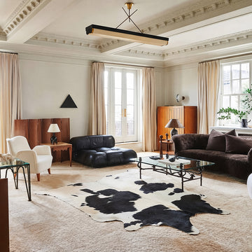 Black and white cowhide rug in a herringbone-floored dining nook