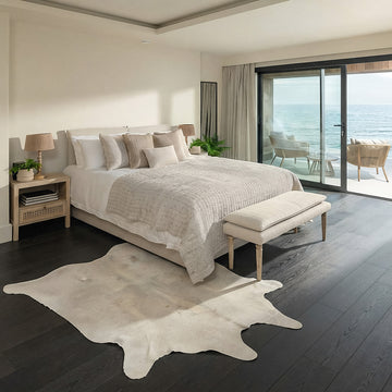 Ivory speckled cowhide rug styled on the floor of a coastal ocean-view bedroom