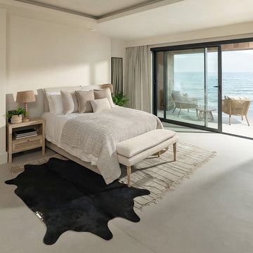 Black cowhide rug in a coastal ocean-view bedroom