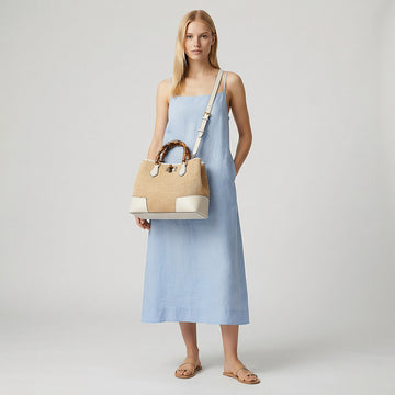 Model wearing the White Ginevra Bamboo-Handle Raffia Bag by Clemés crossbody, studio shot