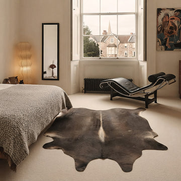 Dark chocolate cowhide rug in an elegant Georgian bedroom