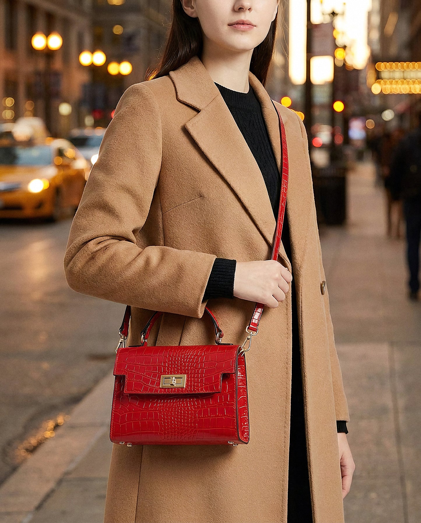 Woman with the Red Margot Croc crossbody bag on an evening city street with lights