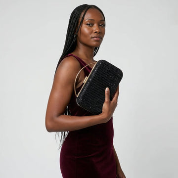 Model with the Black Odette Crystal Minaudière Clutch under her arm, studio shot