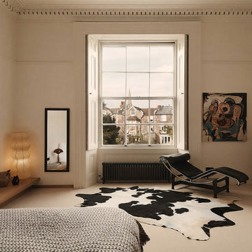 Black and white cowhide rug styled on the floor of an elegant Georgian bedroom