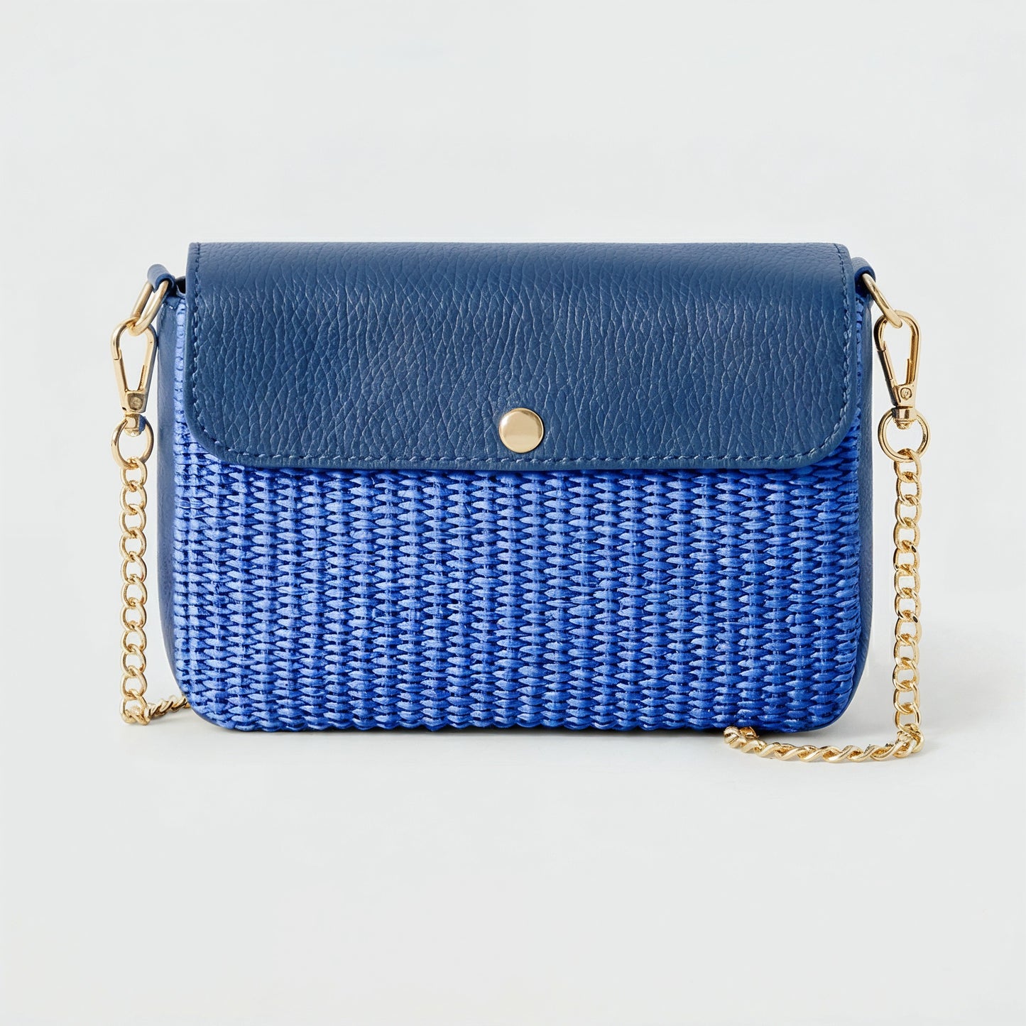 Élodie raffia and leather flap crossbody bag in blue on a light grey studio background
