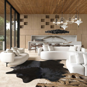 Black cowhide rug in a bright loft living room