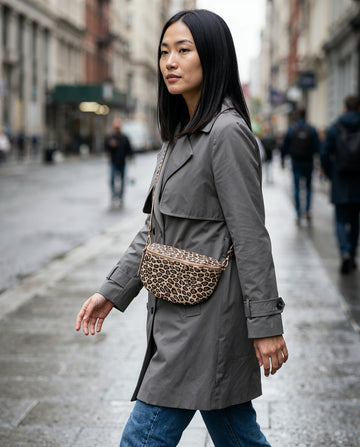 Woman wearing the Matt Light Taupe Leopard Romy bum bag on an overcast city street