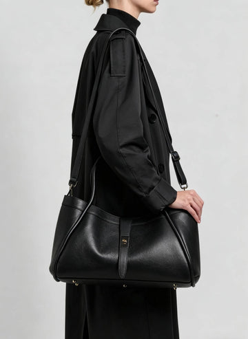 Woman wearing the Black Bianca Large tote on her shoulder in a black jacket