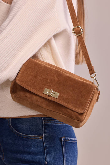 Woman carrying the Chocolate Iliane suede bag crossbody over jeans
