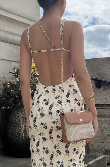 Woman wearing the Oyster Élodie flap bag on a chain strap in a floral dress