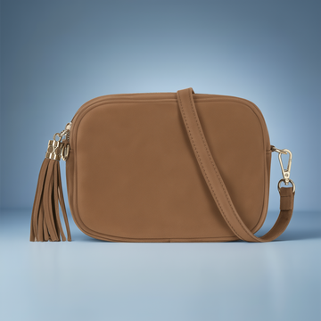 Éloise Real Suede Tassel Camera Bag by Clemés in Tan, three-quarter studio shot on grey background
