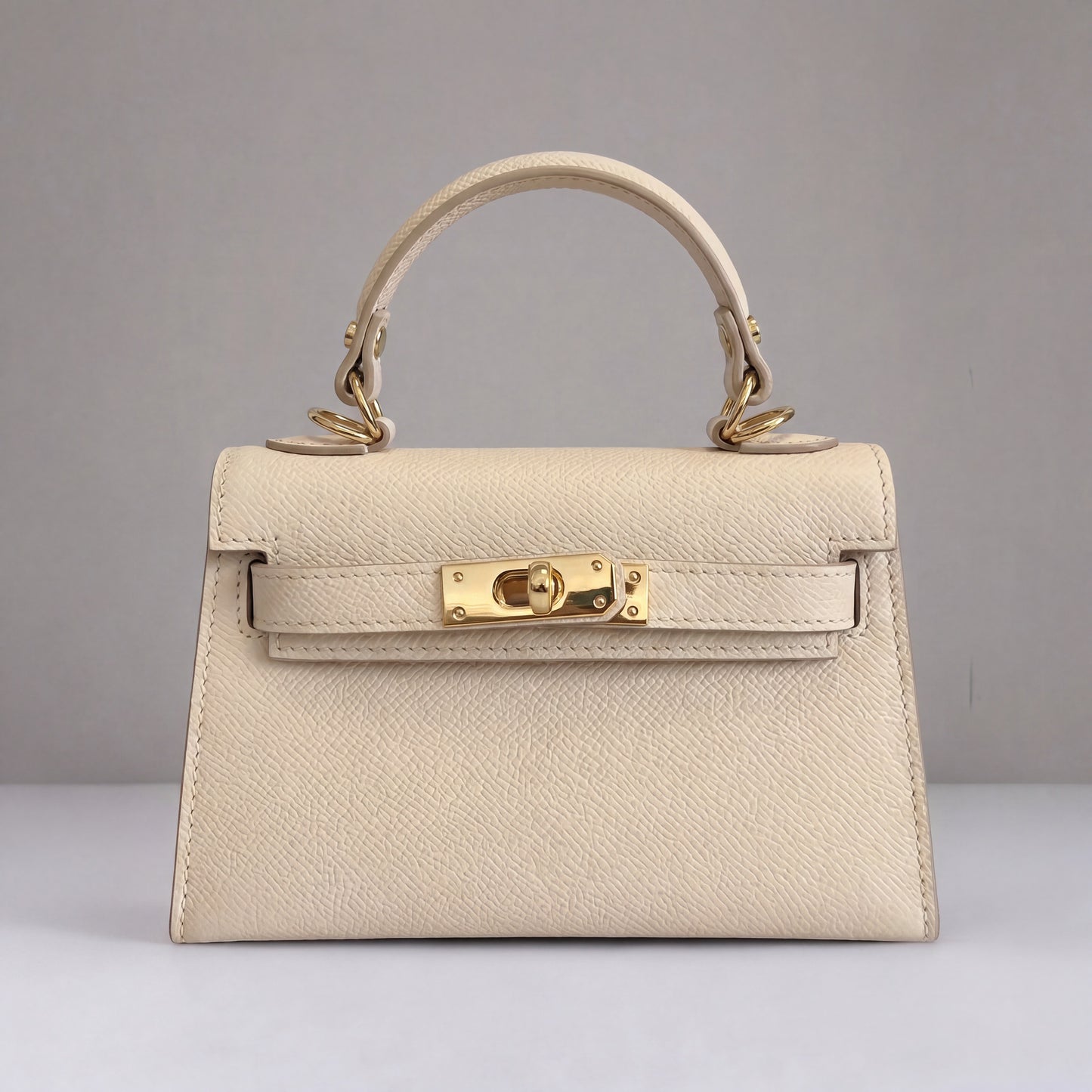 Clemés Mini Kelly Epsom Leather Handbag in Light Ivory - front three-quarter studio shot