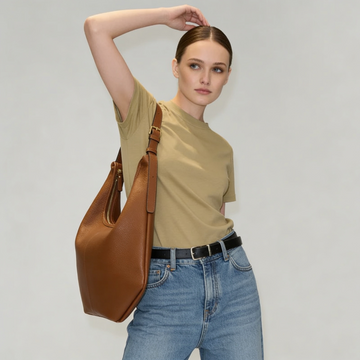 Woman wearing the Tan Ludovica hobo bag on her shoulder in an olive tee