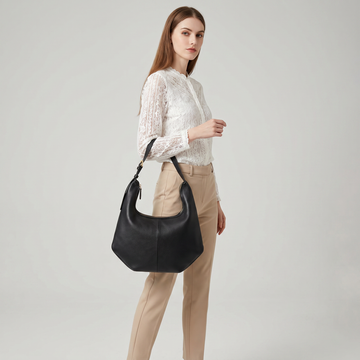 Woman wearing the Black Ludovica hobo bag on her shoulder