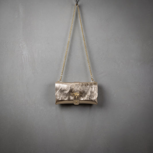 Anima Suede Leather Metallic Clutch Shoulder Bag by Clemés in Champagne, studio shot on grey background