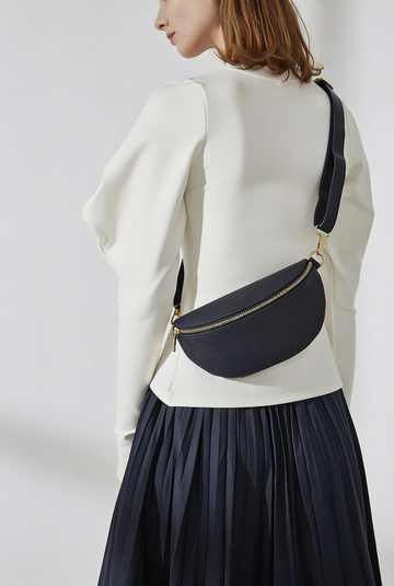 Woman wearing the Black Romy bum bag crossbody in a cream sweater