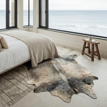 Caramel and ivory exotic printed cowhide rug styled on the floor of an editorial interior