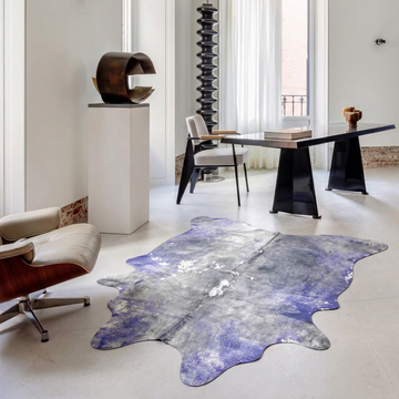 Violet and Grey metallic cowhide rug styled on the pale stone floor of a bright minimalist study