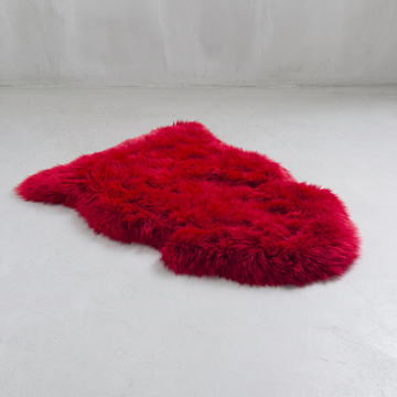 Wildfire red single sheepskin rug laid flat on a pale grey floor