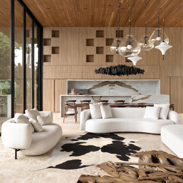 Speckled black and white cowhide rug styled on the floor of a bright loft living room