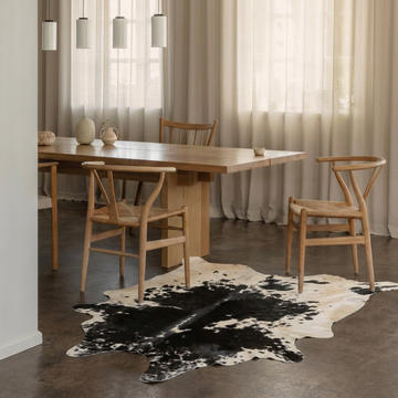 Caramel and ivory exotic printed cowhide rug styled on the floor of an editorial interior