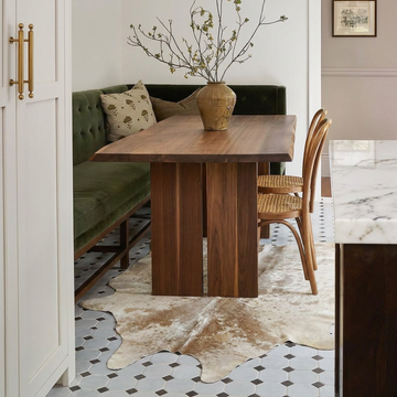 Caramel and ivory exotic printed cowhide rug styled on the floor of an editorial interior