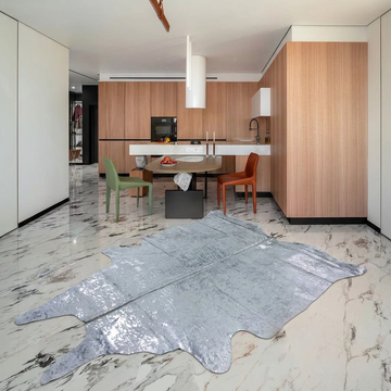 Silver on off-white metallic cowhide rug styled on the marble floor of a modern minimal kitchen-dining room